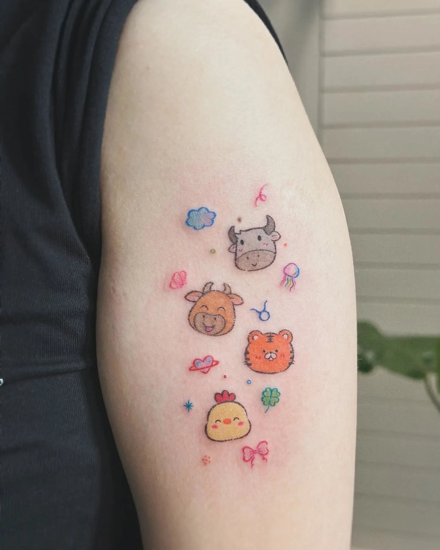 cute colorful animals minimalist tattoo on woman upper arm