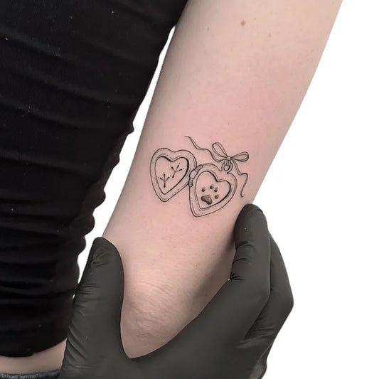heart box with animal paw outline fine line tattoo on woman upper arm