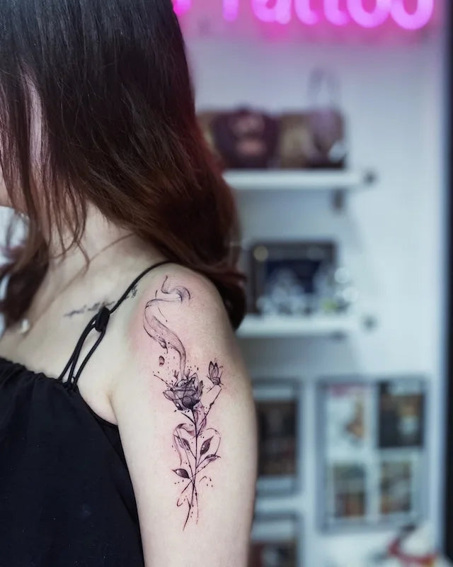 black floral sketh tattoo on woman upper arm