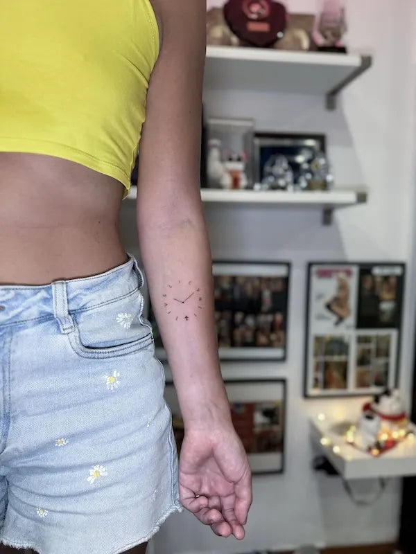 simple minimalist clock tattoo on woman forearm