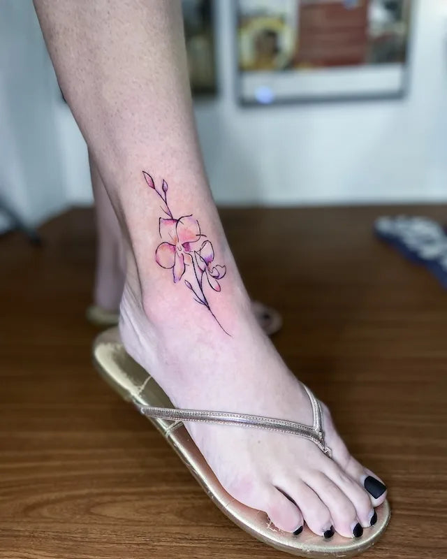 simple flower outline tattoo on woman ankle foot