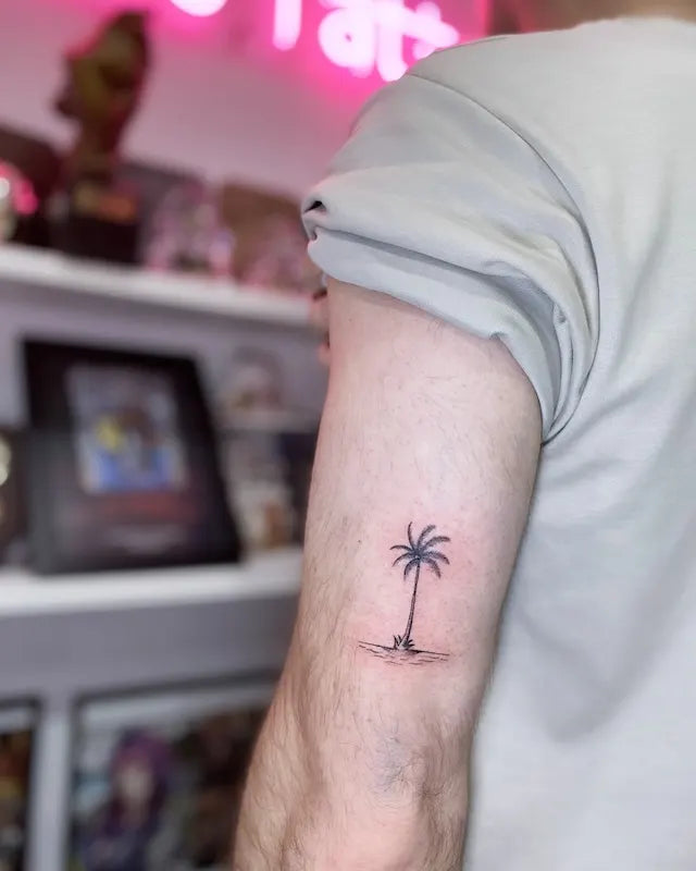 minimal palm tree tattoo on man upper arm
