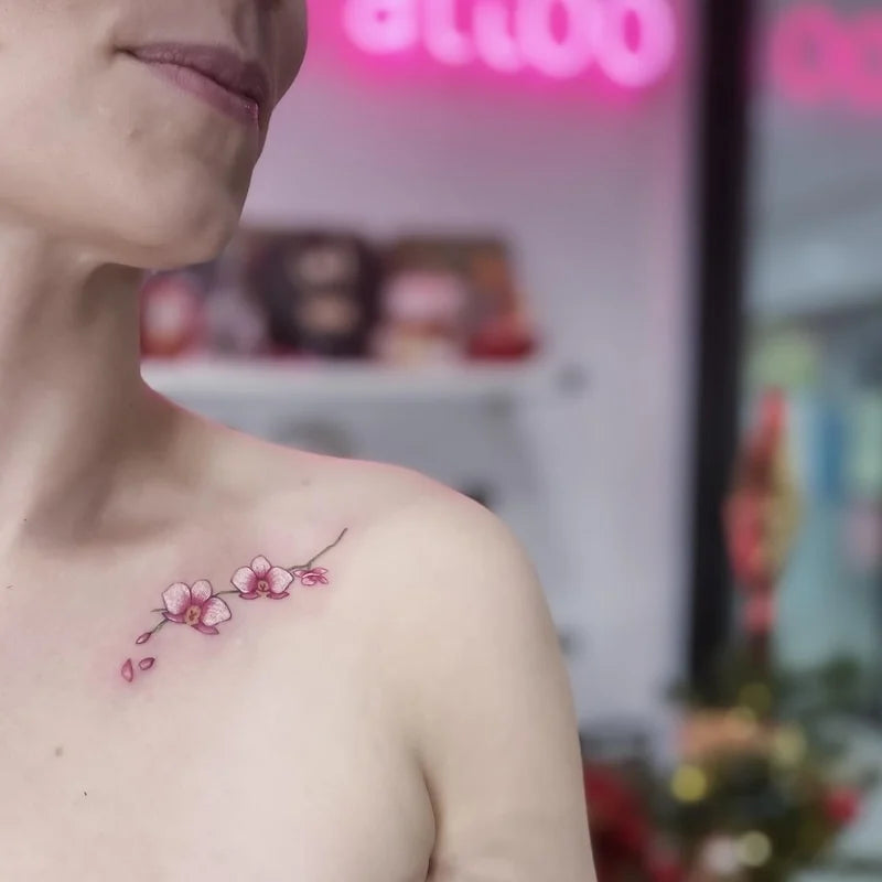 shiny cherry blossom flower tattoo on woman shoulder