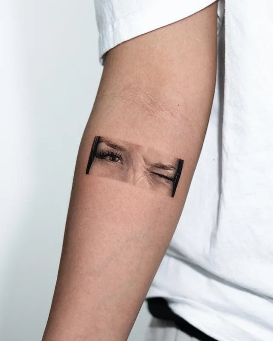 black and grey realism woman eyes tattoo on inner forearm