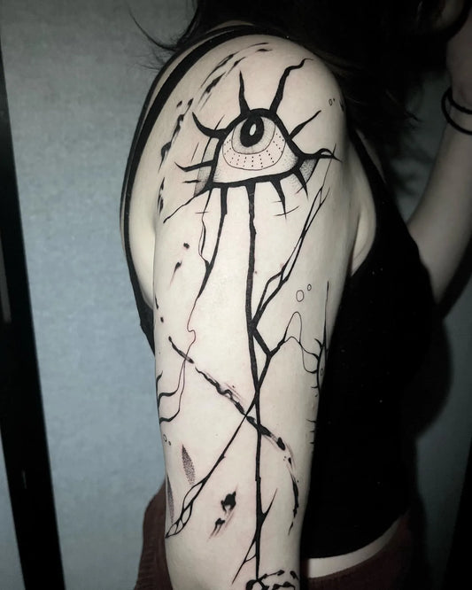 abstract black lines with horror eye upper arm tattoo