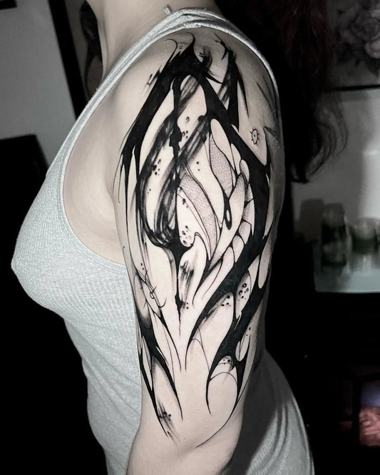 abstract black brush stroke upper arm tattoo