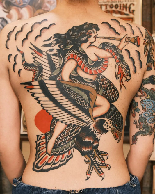 Back with large detailed traditional tattoo of a woman riding an eagle with a snake