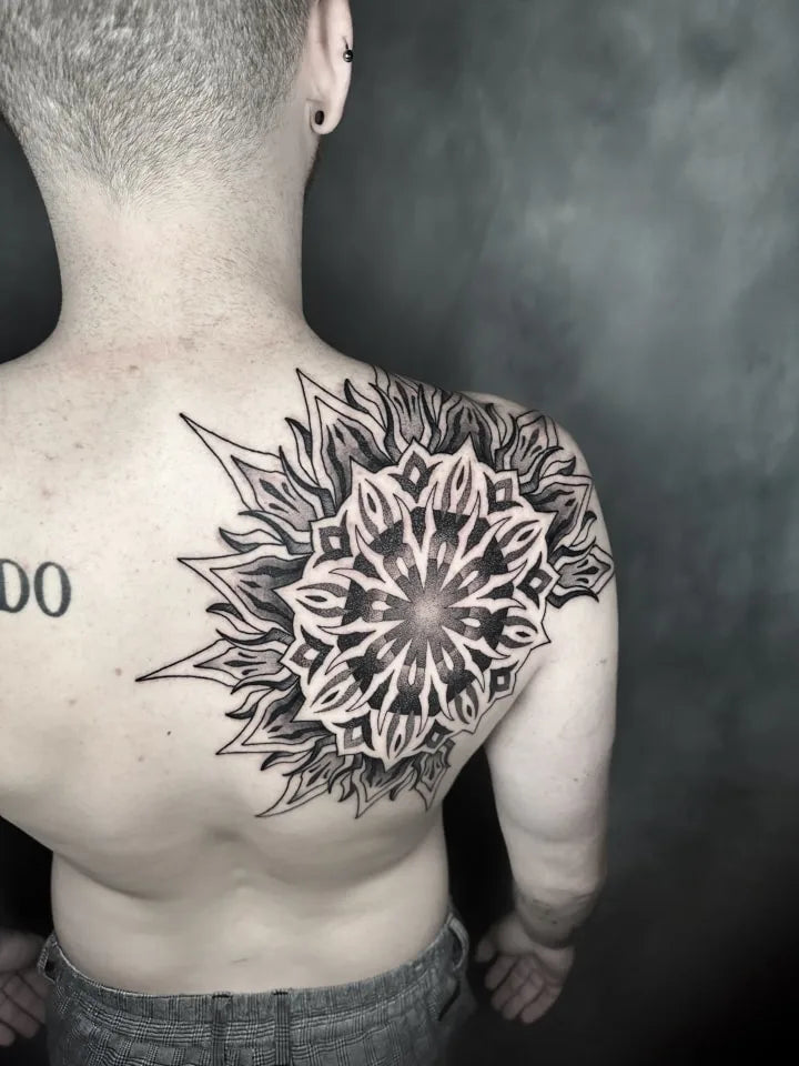 large geometric tattoo on man back shoulder