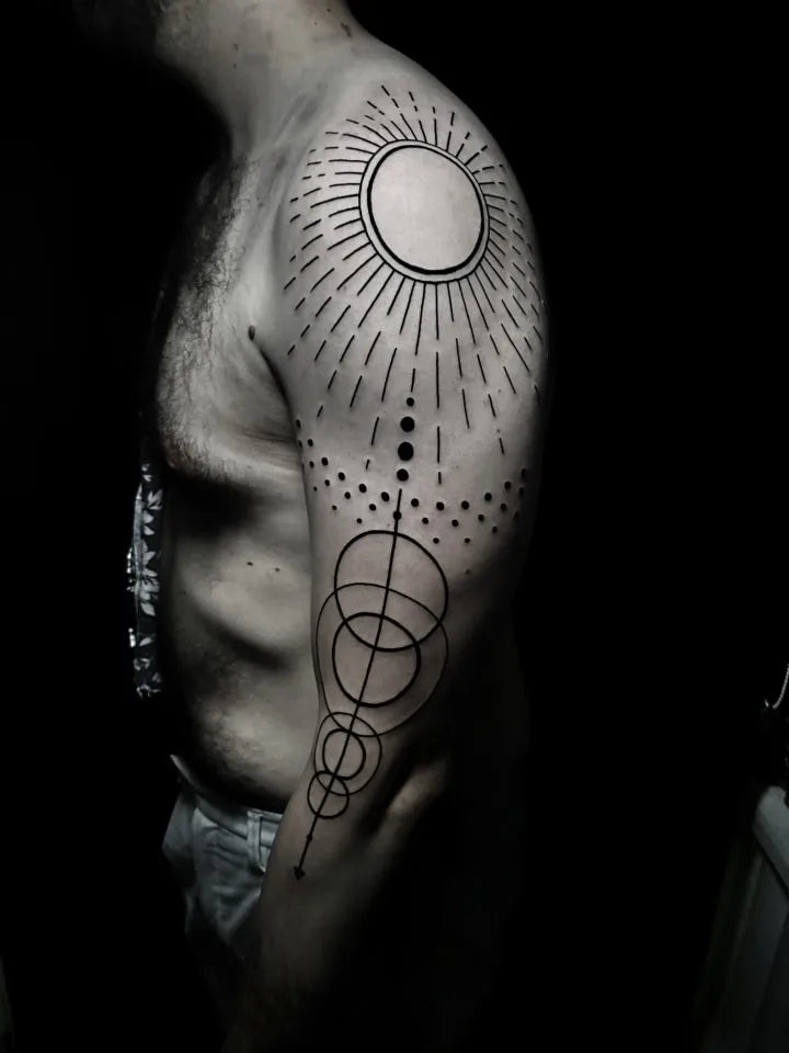 geometric pattern tattoo sunburst on man shoulder and arm