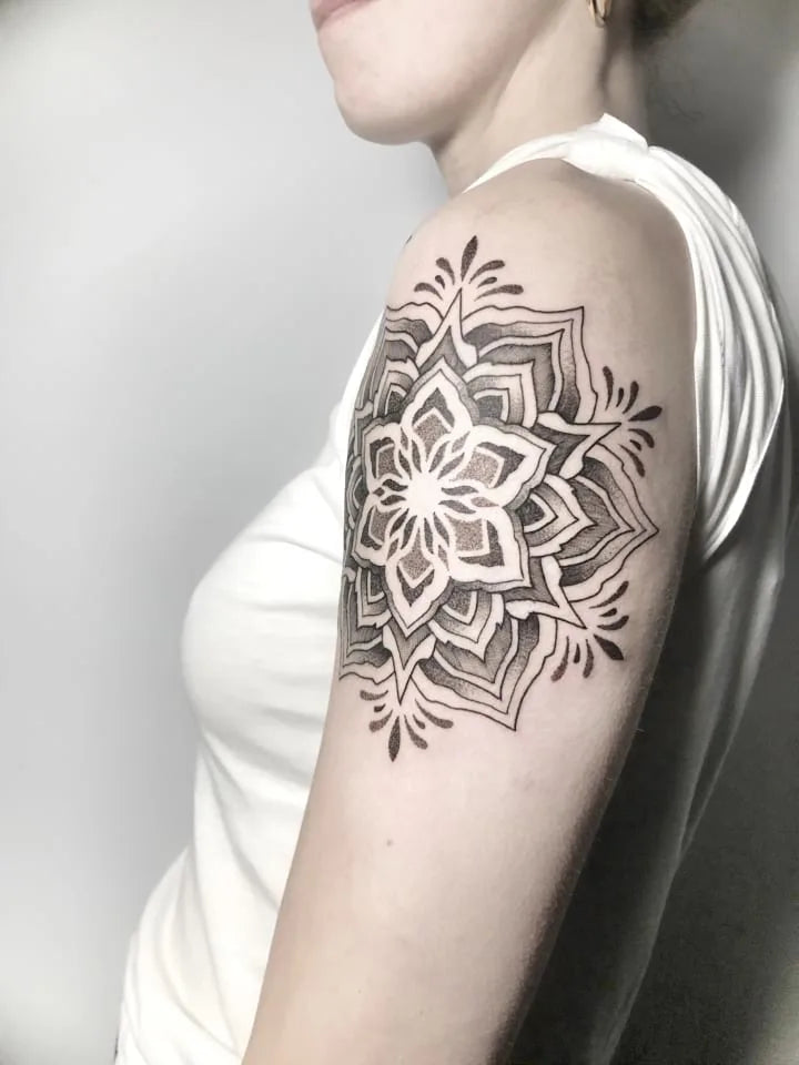 geometric mandala tattoo on woman upper arm