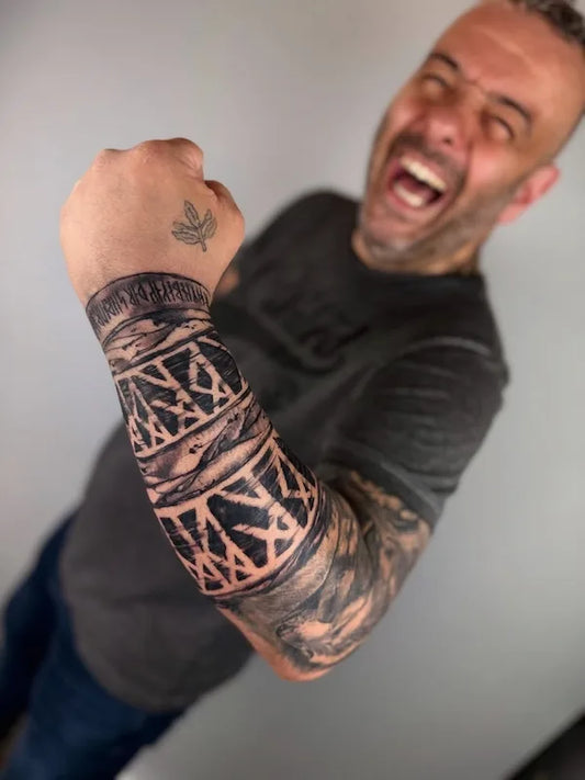 blackwork black and grey arm sleeve tattoo on man forearm
