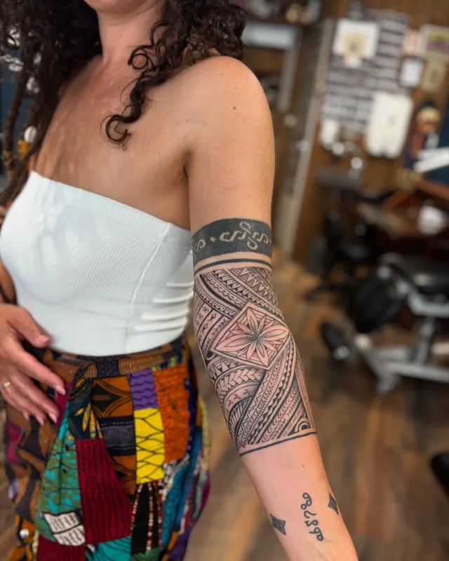 polynesian tribal arm wrap woman tattoo