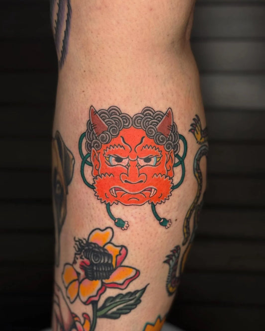 japanese red demon face mask tattoo on leg