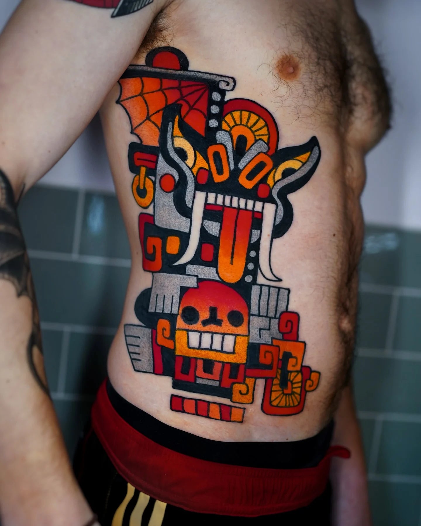 colorful neo traditional tribal tattoo on man rib
