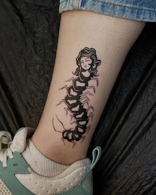 abstract scorpion with woman head blackwork tattoo on ankle leg