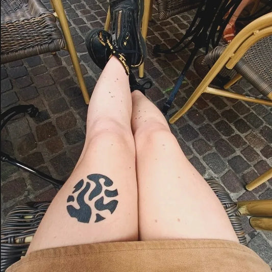 blackwork abstract pattern circle tattoo on woman thigh