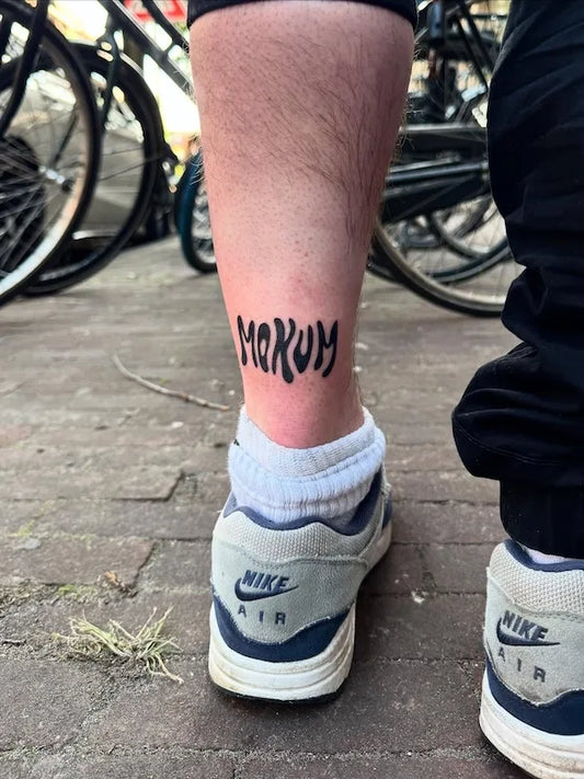 abstract font mokum bold lettering blackwork tattoo on man ankle