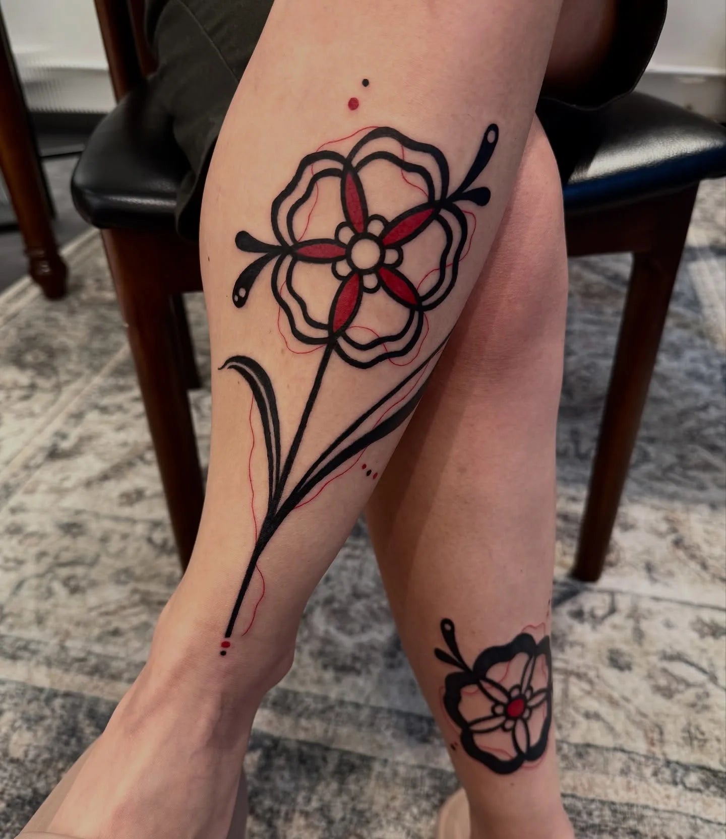 blackwork fine line flower leg tattoo