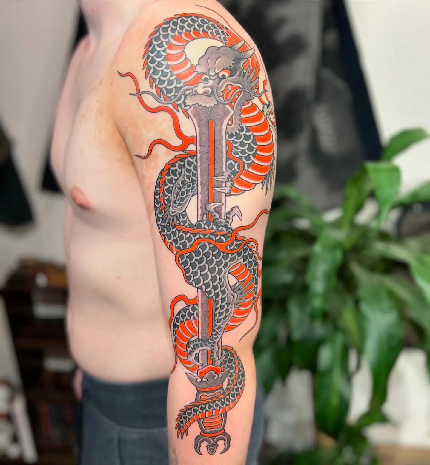 japanese dragon and sword tattoo on man full arm
