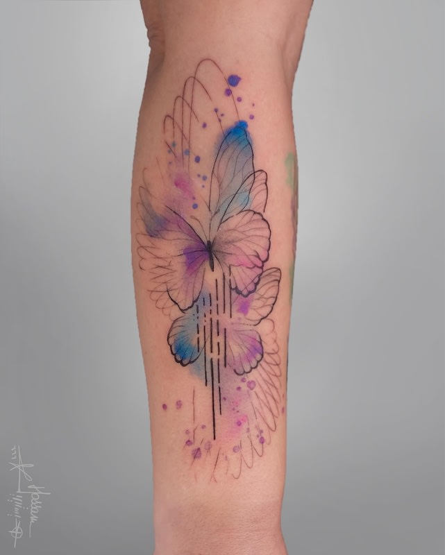 watercolor geometric butterfly tattoo on forearm