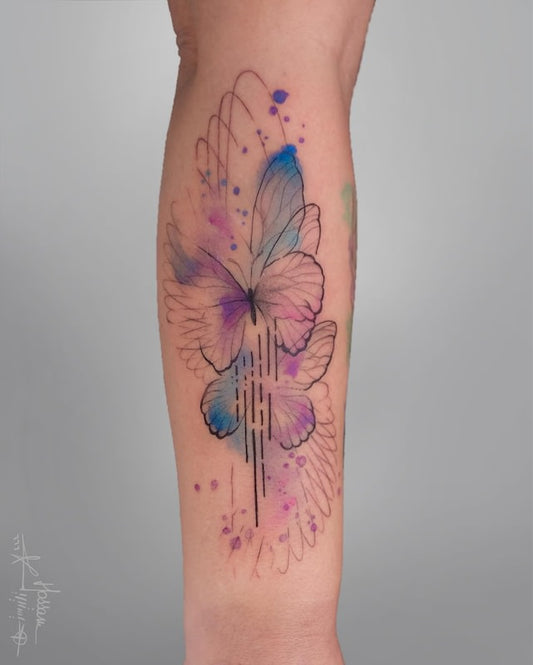 watercolor geometric butterfly tattoo on forearm