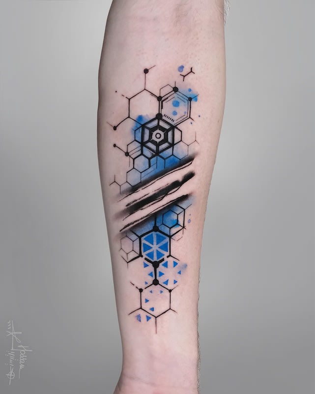 black and blue watercolor honeycomb pattern geometric abstract tattoo on forearm
