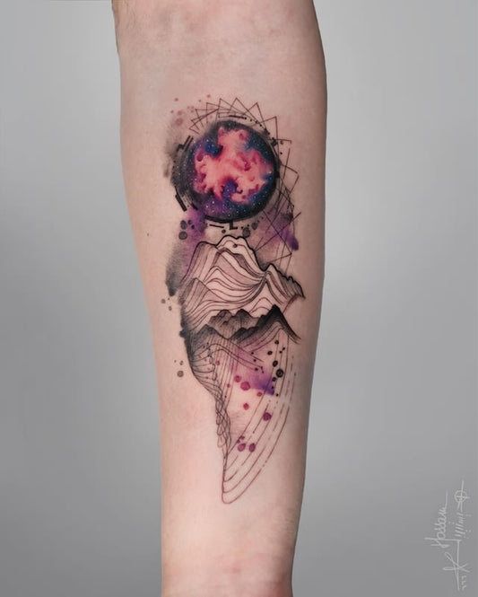 Tattoo of a colorful sphere with geometric mountains on forearm