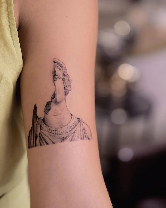 broken greek sculpture black and grey dotwork tattoo on woman bicep