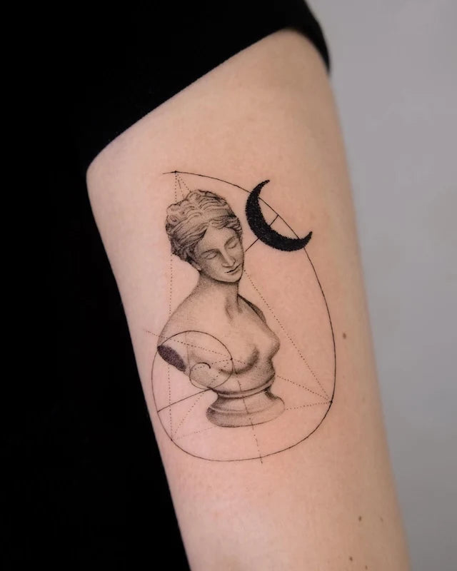 venus sculpture moon dotwork black and grey tattoo on upper arm