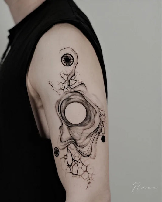 abstract black watercolor brush stroke circles tattoo on man upper arm
