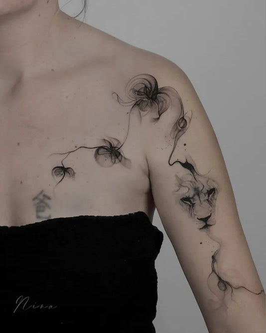 abstract black watercolor floral lion tattoo on woman shoulder and arm