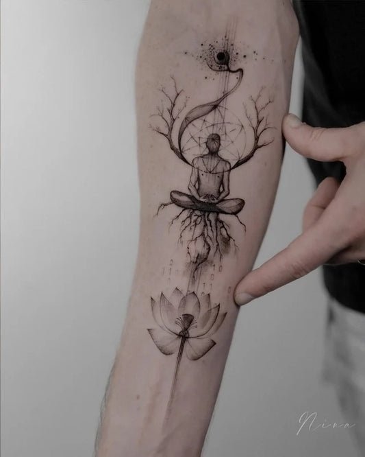 abstract geometric tattoo of a person meditating with branches and a lotus flower on forearm