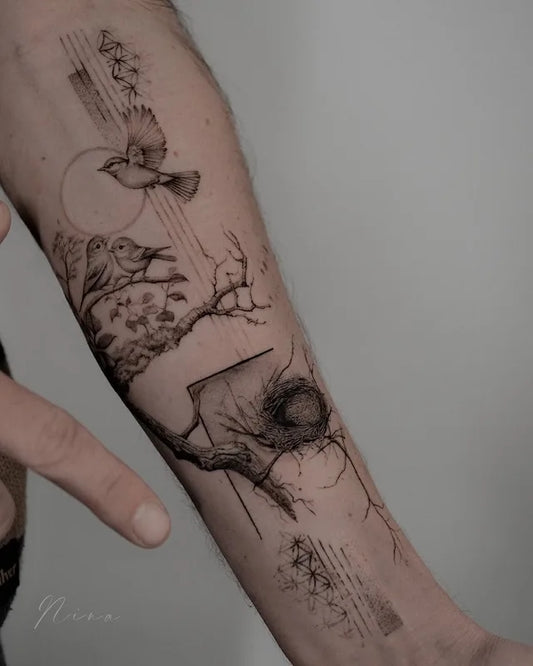 abstract tattoo of birds and nature elements on forearm