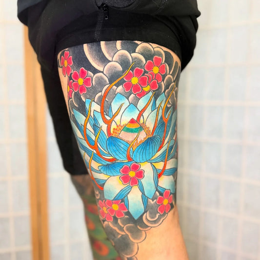 colorful japanese lotus flower tattoo on man thigh half sleeve
