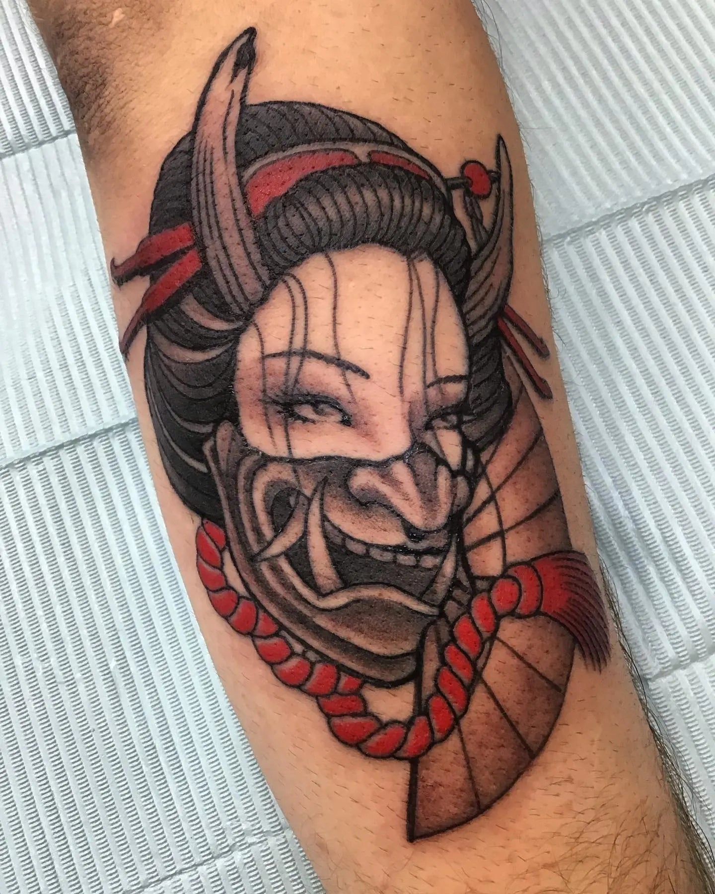Tattoo of a samurai mask with red accents