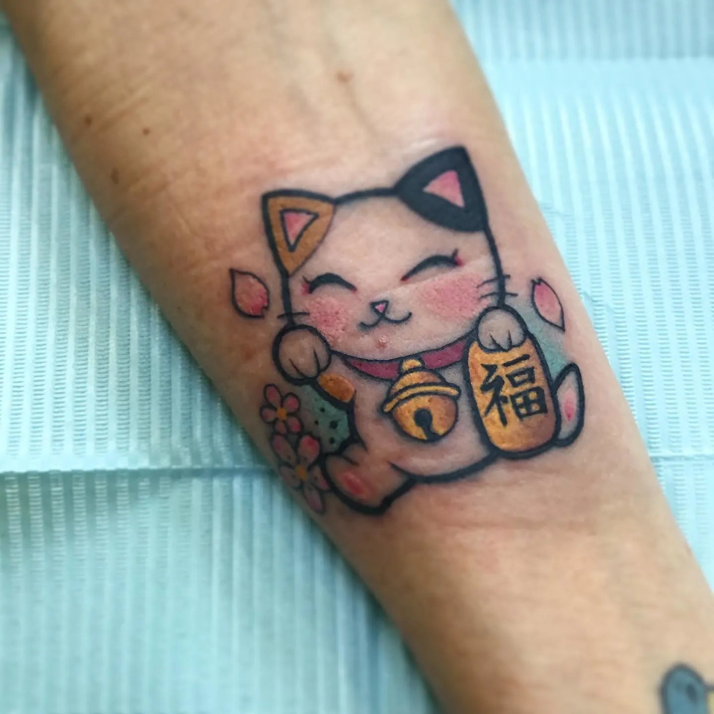 japanese lucky cat tattoo on forearm