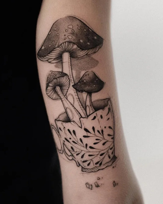 black and grey three mushrooms grow in cup illustrative dotwork tattoo on arm