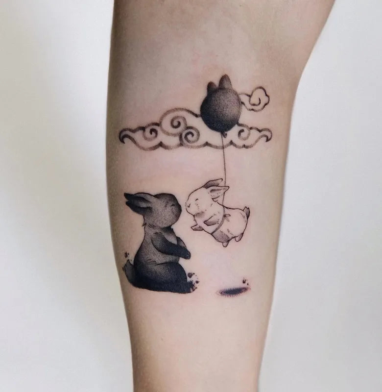 two black and white rabbits bunnies with a balloon tattoo