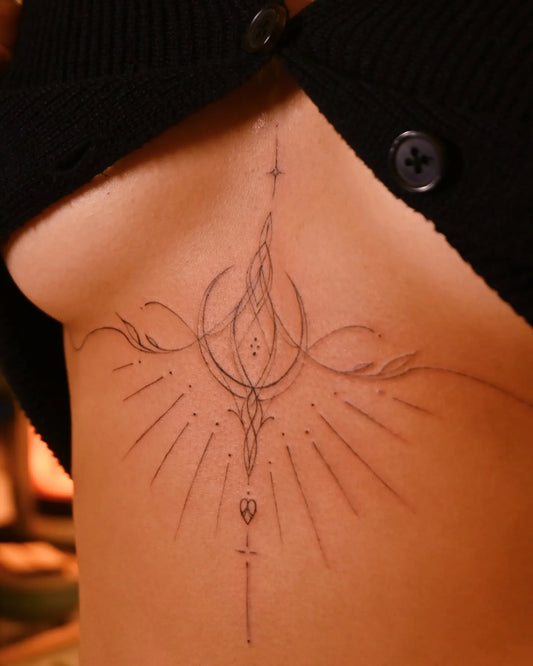 feminine ornamental fine line sternum tattoo 