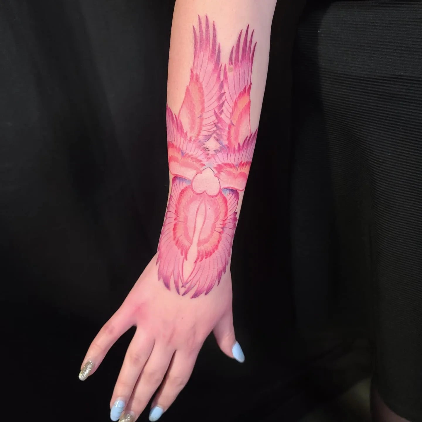 pink phoenix wings forearm tattoo