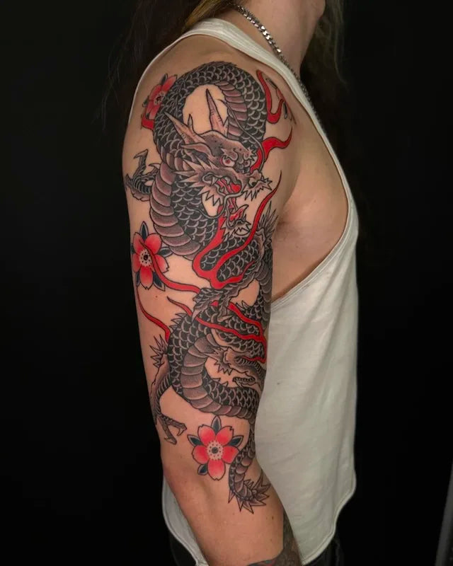 traditional japanese dragon tattoo with red accents on upper arm sleeve