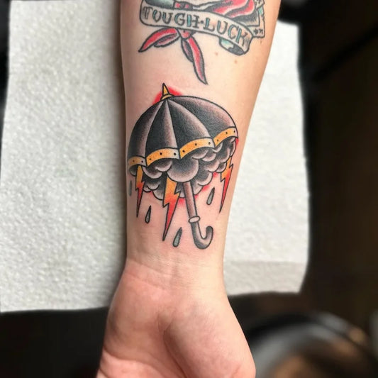 american traditional black umbrella tattoo with thunderstorm and raindrops on wrist