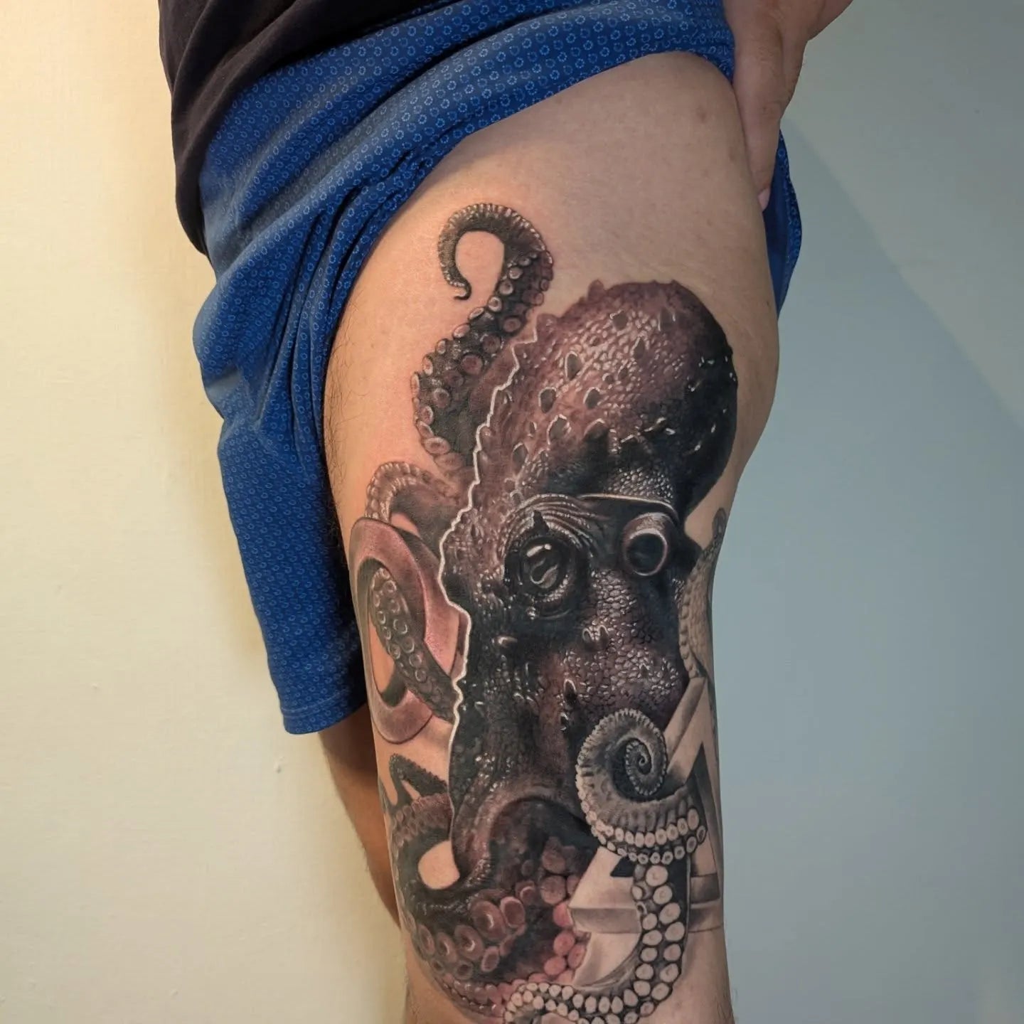 realistic octopus tattoo on man thigh