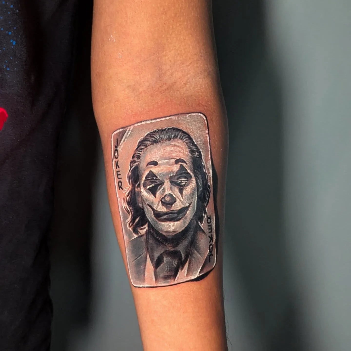 joker playing card white ink tattoo on forearm