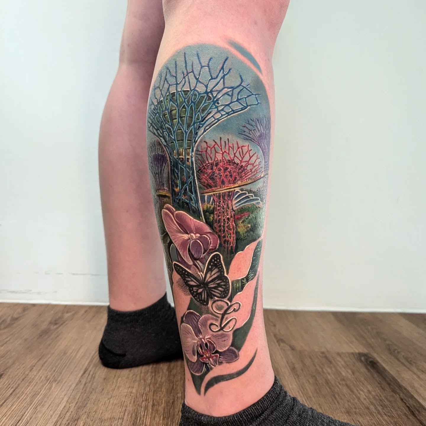 Singapore Gardens by the Bay landscape with floral butterflies color realism tattoo on calf leg