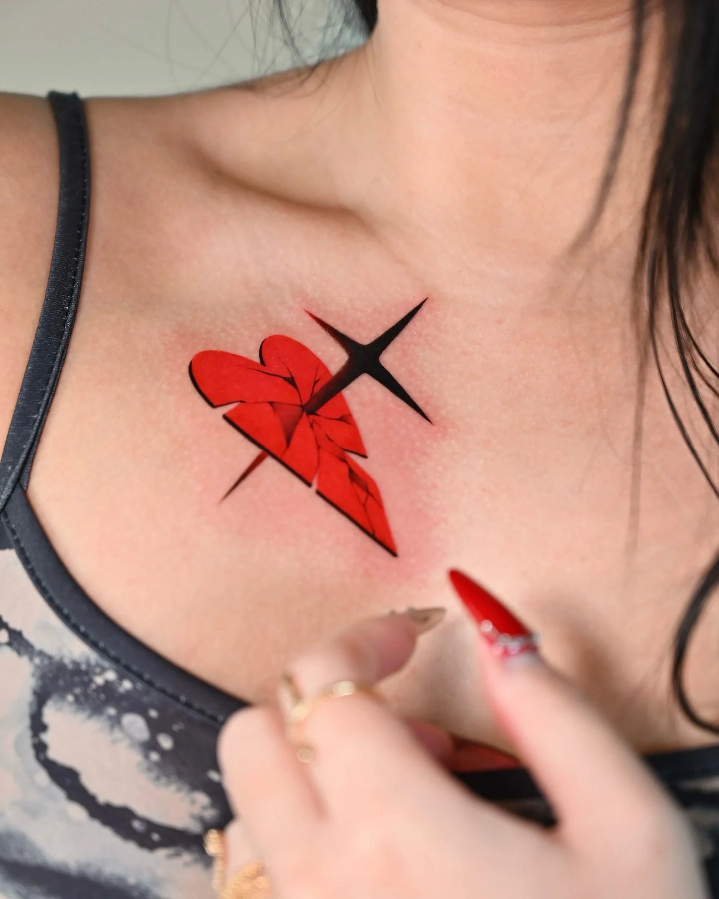 broken red heart stabbed by cross woman shoulder tattoo