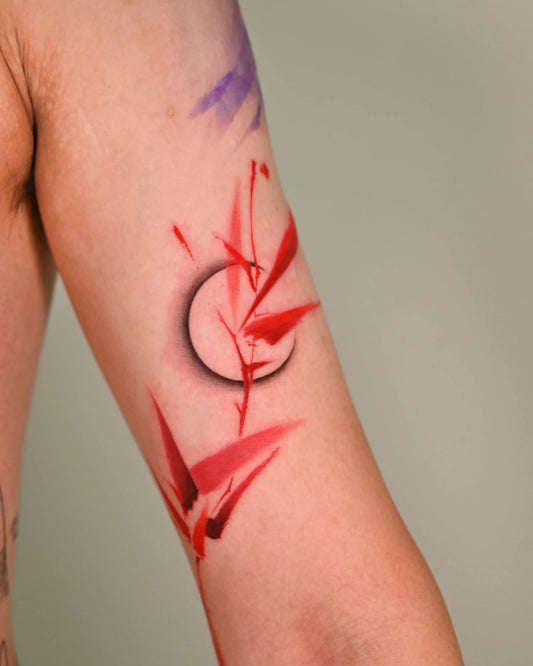 red leaves bicep tattoo