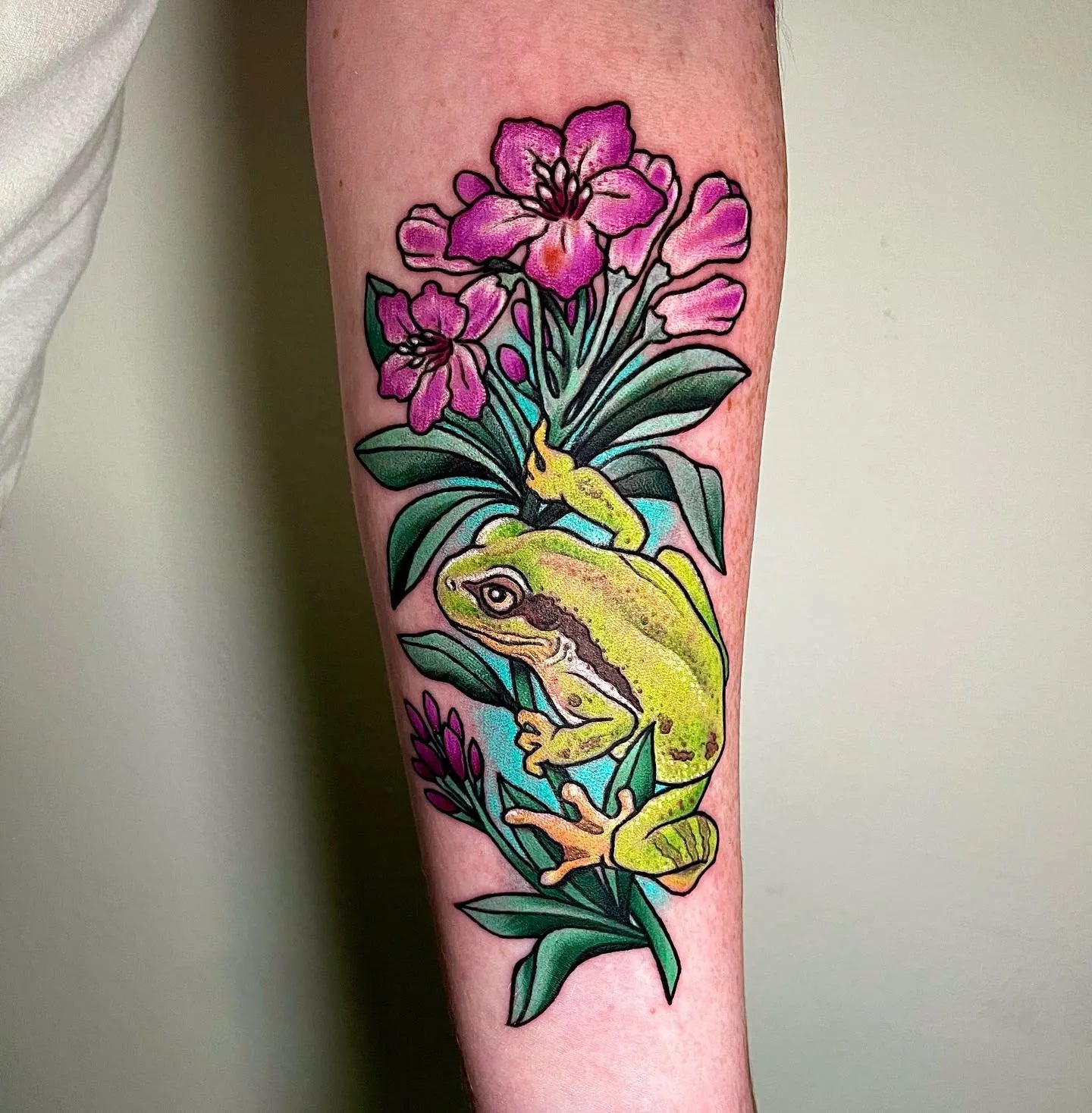 frog and flower new school forearm tattoo