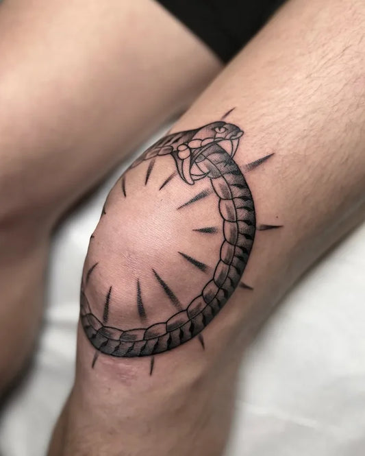 traditional snake ouroboros tattoo on man knee