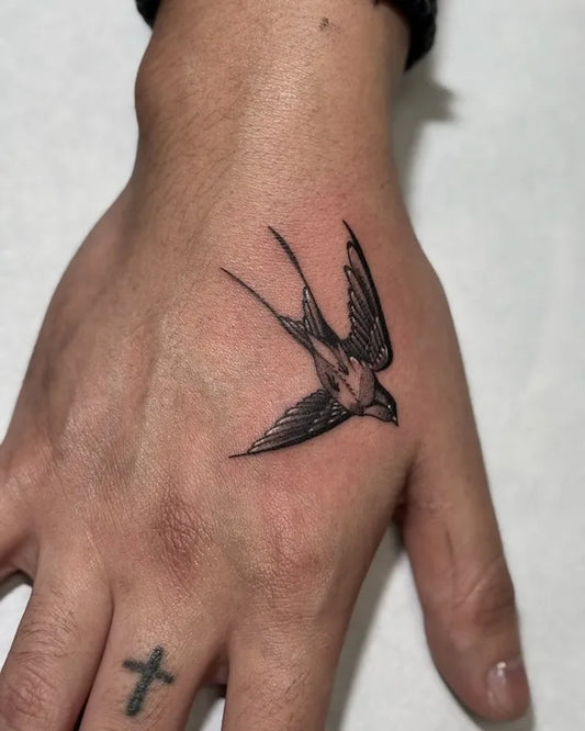 traditional black and grey swallow tattoo on hand